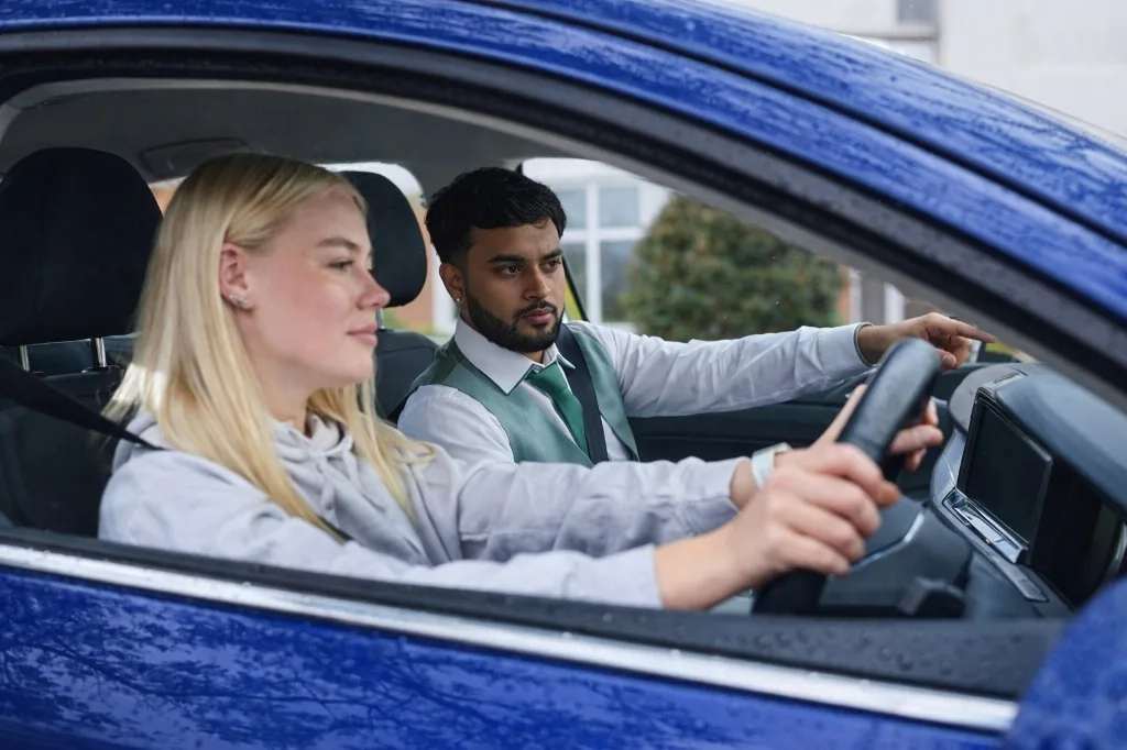 Apisan Thavakumar, DVSA-approved driving instructor standing next to dual-control car in Pinner, North London